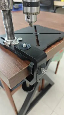 C1 clamp gripping a table edge with a station base bolted to it
