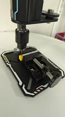 V1 vise bolted to a T1 station base, holding a workpiece under the tap